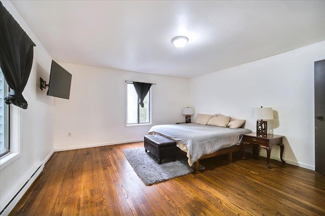 bedroom featuring dark wood-type flooring and a baseboard heating unit