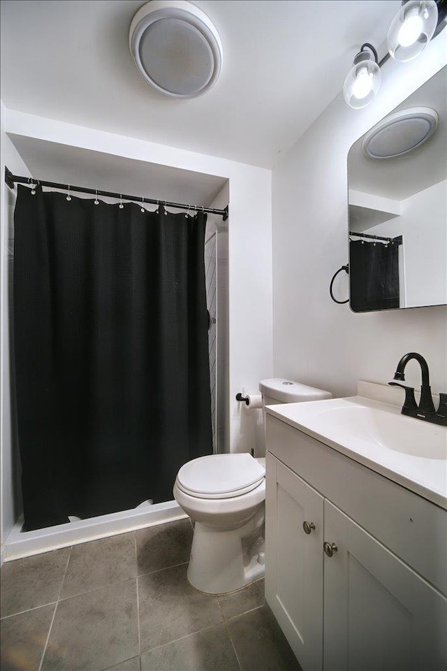 bathroom with tile patterned flooring, vanity, and toilet