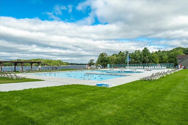 view of pool featuring a lawn, a water view, and a patio