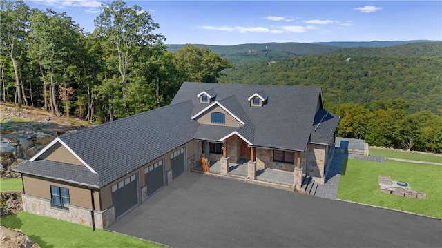 view of front of home featuring a porch, a garage, and a front lawn