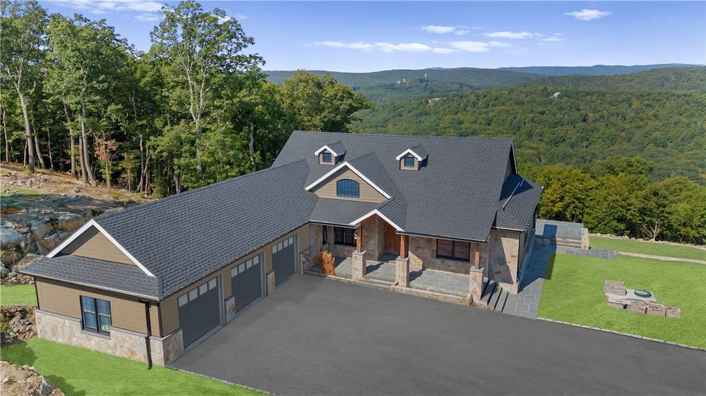 55 Ridgecrest, Putnam Valley, NY 10537 - view of front facade featuring stone siding, a porch, a wooded view, a front lawn, and asphalt driveway