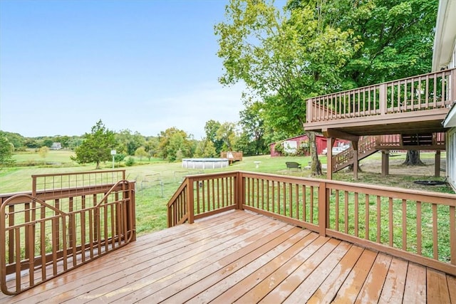 wooden terrace with a pool and a lawn