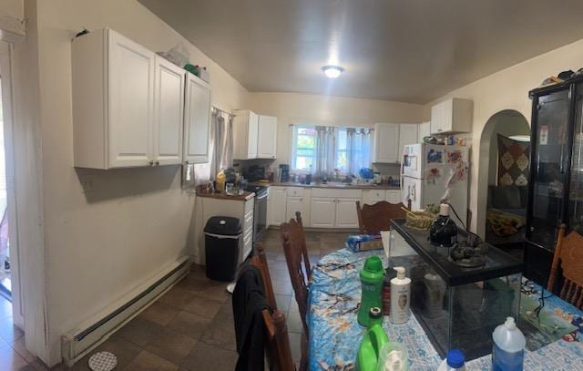 kitchen featuring stainless steel range, white cabinets, white refrigerator, and a baseboard heating unit