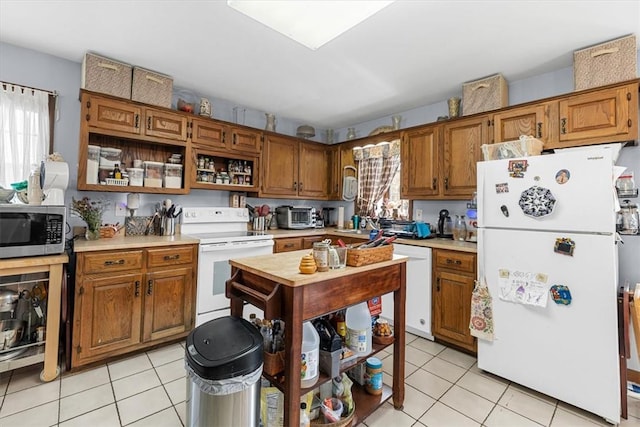 kitchen featuring light tile patterned flooring and white appliances