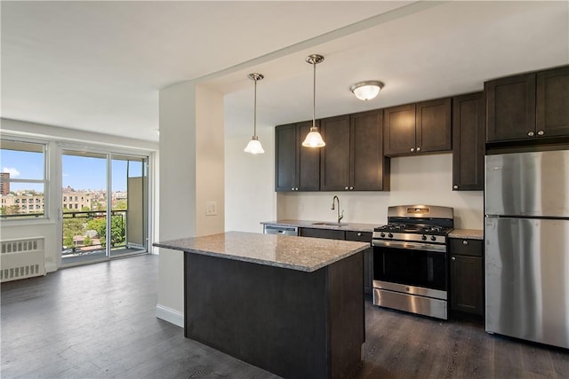 kitchen with dark hardwood / wood-style flooring, light stone countertops, stainless steel appliances, and hanging light fixtures