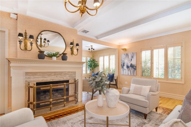 living room featuring beam ceiling, wood-type flooring, a fireplace, and a chandelier