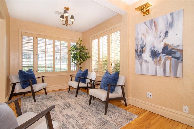 sitting room with a notable chandelier and wood-type flooring