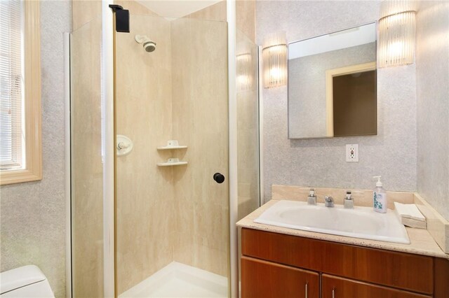 bathroom featuring vanity, toilet, and walk in shower