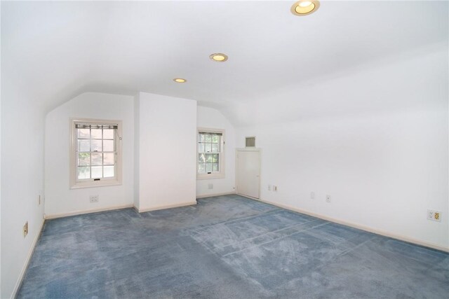 bonus room featuring dark carpet and vaulted ceiling