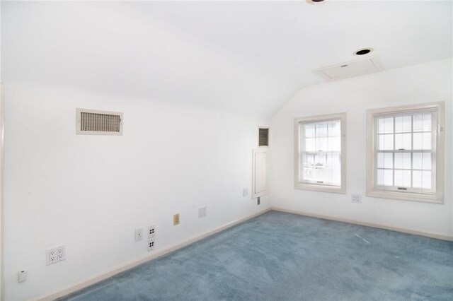 carpeted empty room featuring lofted ceiling