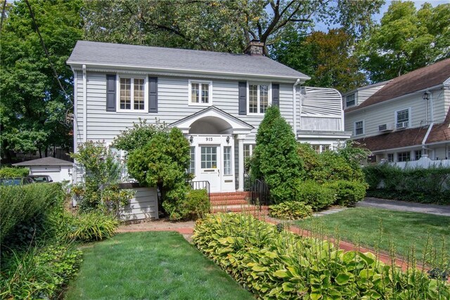 colonial home featuring a front lawn