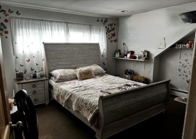 bedroom with baseboard heating, crown molding, and dark colored carpet