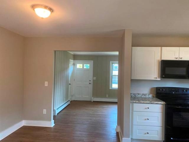 kitchen featuring black appliances, dark hardwood / wood-style floors, white cabinetry, and a baseboard heating unit