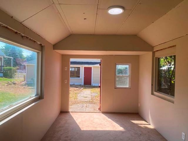 hall featuring carpet and lofted ceiling