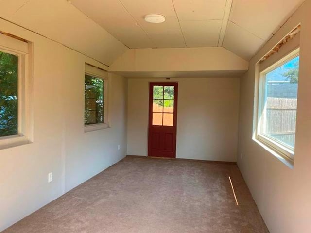 carpeted spare room featuring lofted ceiling