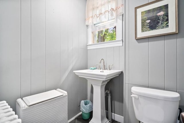 bathroom with sink, radiator heating unit, and toilet