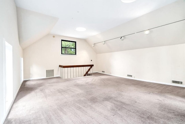 additional living space with vaulted ceiling and carpet flooring