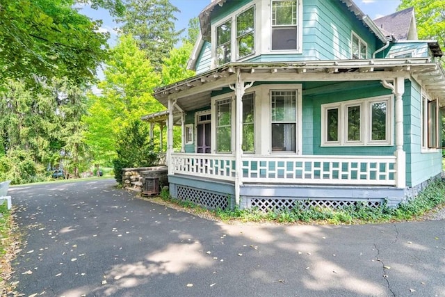 view of side of home featuring covered porch