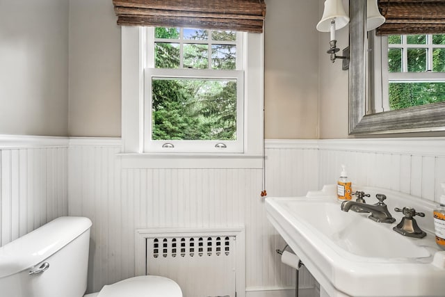 105 Walworth Ave, Scarsdale, NY 10583 - half bath featuring radiator, a wainscoted wall, toilet, plenty of natural light, and a sink