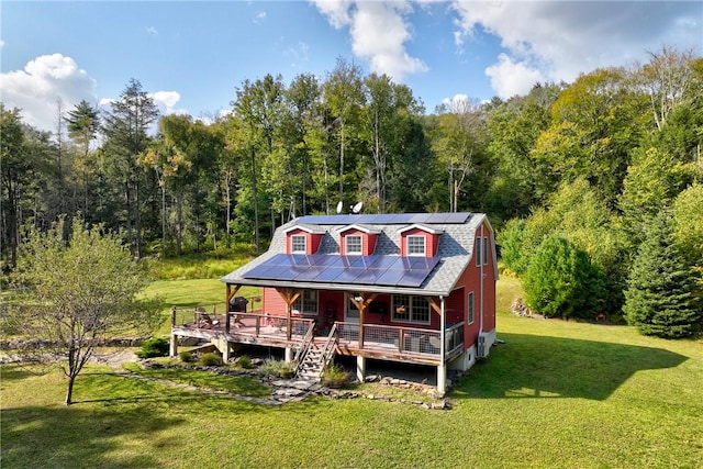 exterior space with solar panels, a deck, and a lawn