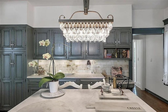 kitchen featuring backsplash, dark wood-type flooring, an inviting chandelier, breakfast area, and hanging light fixtures