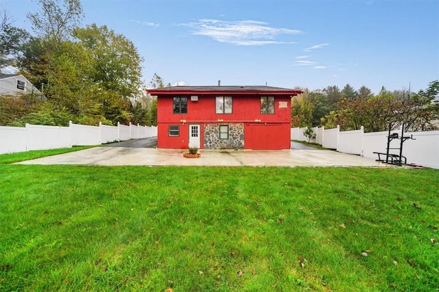 back of house featuring a patio and a lawn