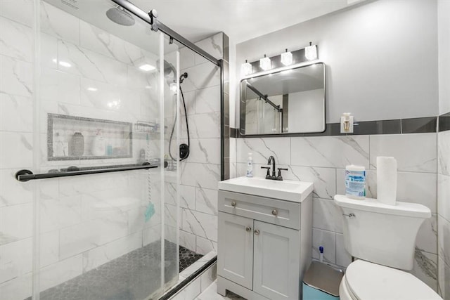 bathroom featuring vanity, toilet, an enclosed shower, and tile walls