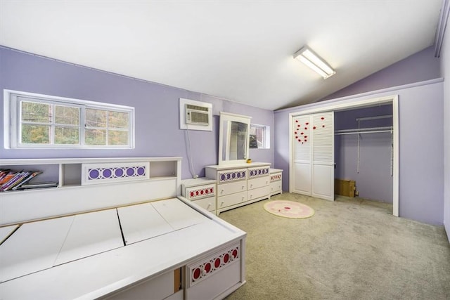 carpeted bedroom featuring a wall mounted air conditioner, vaulted ceiling, and a closet