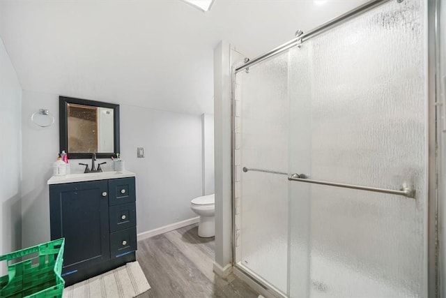 bathroom featuring toilet, hardwood / wood-style floors, vanity, and walk in shower