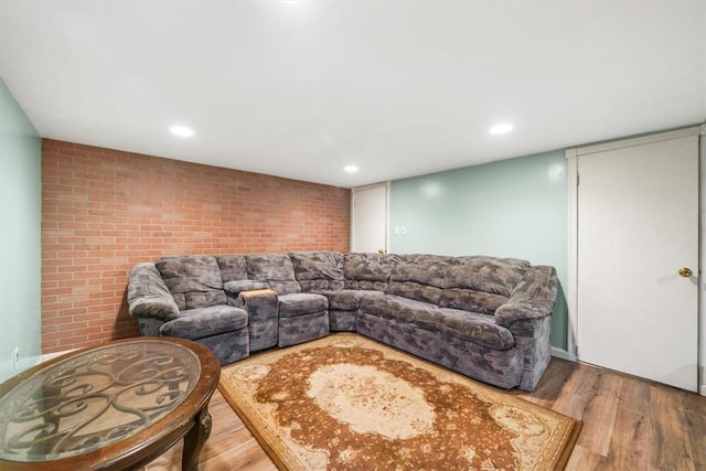 living room featuring wood-type flooring and brick wall