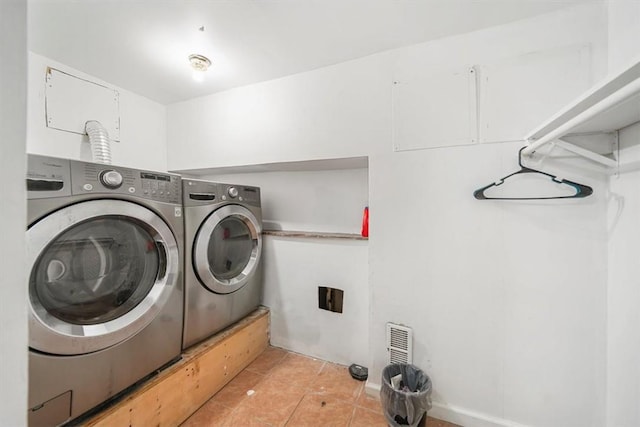 washroom with washing machine and clothes dryer and light tile patterned floors