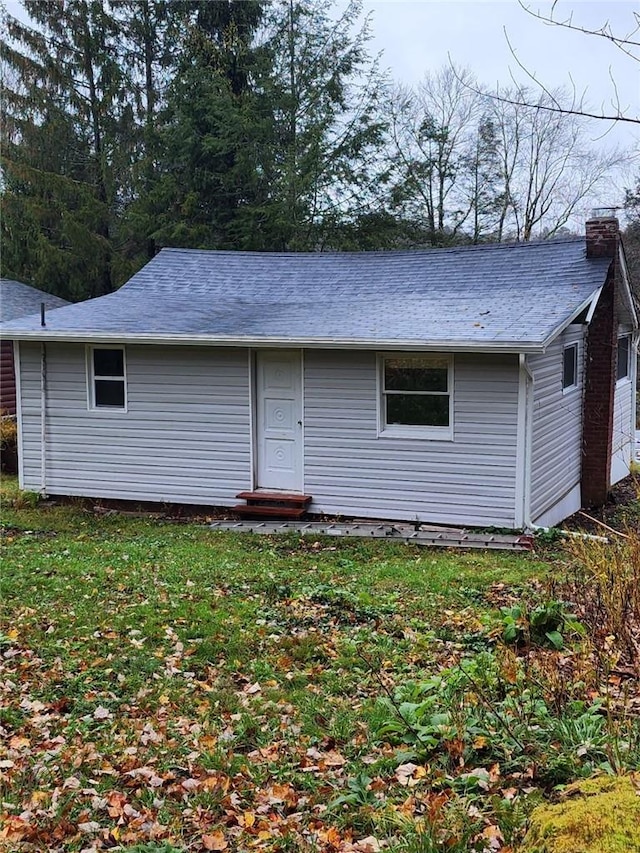 rear view of property featuring a yard