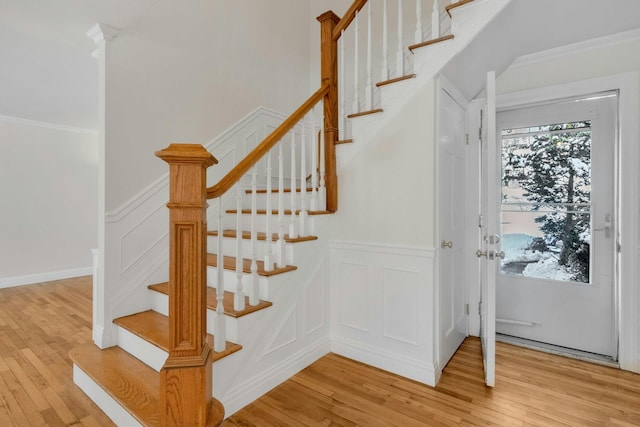 stairway featuring wood-type flooring and ornamental molding