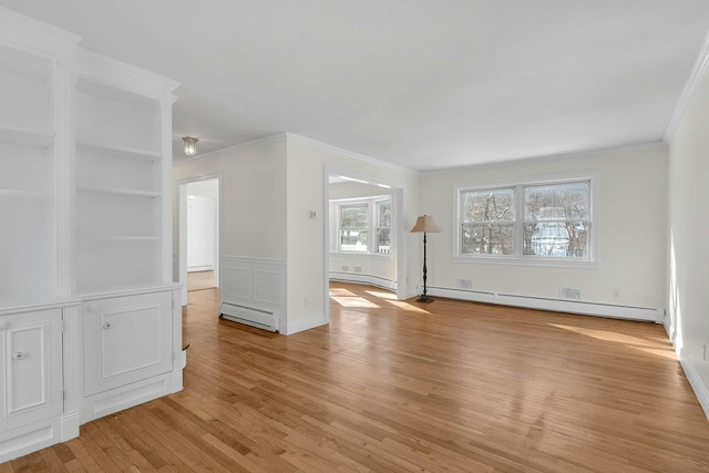 empty room with crown molding, a baseboard heating unit, and light hardwood / wood-style floors