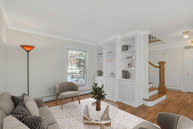 living room with crown molding, a baseboard radiator, built in features, and light wood-type flooring