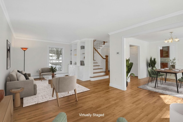 living room with hardwood / wood-style flooring, ornamental molding, and a notable chandelier