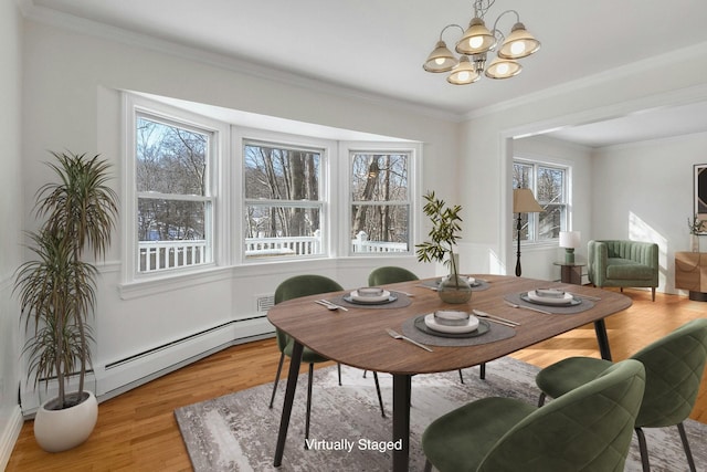 dining space with a baseboard radiator, ornamental molding, light hardwood / wood-style flooring, and a notable chandelier