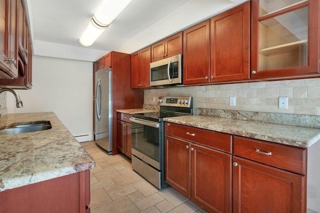 kitchen with sink, backsplash, stainless steel appliances, and light stone countertops