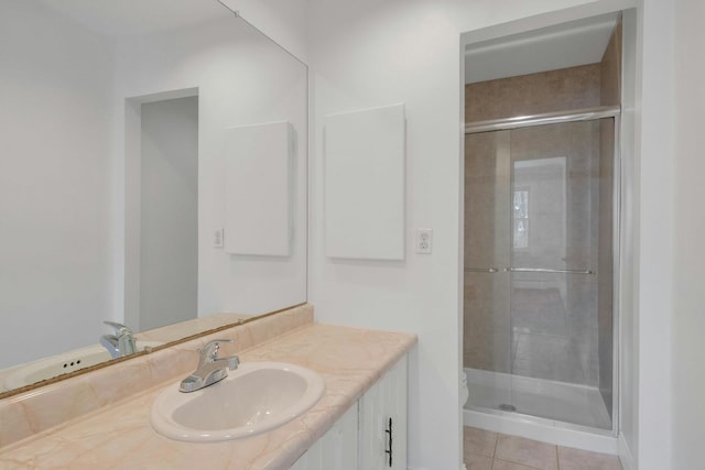 bathroom with vanity, toilet, a shower with shower door, and tile patterned flooring