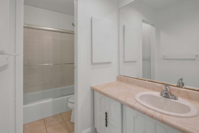 full bathroom with tiled shower / bath combo, vanity, tile patterned floors, and toilet