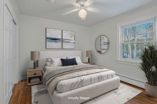 bedroom featuring a baseboard radiator, dark wood-type flooring, ornamental molding, and a closet