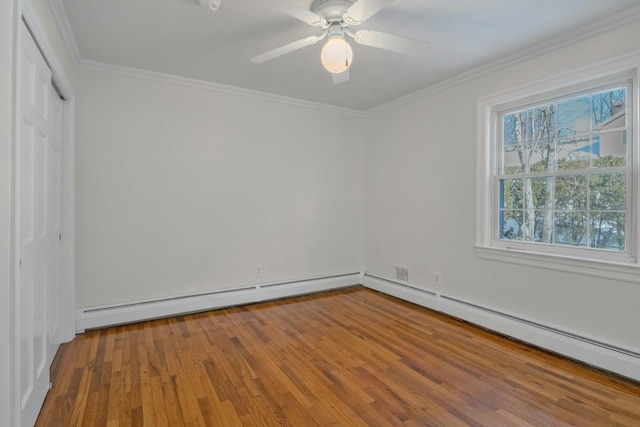 interior space featuring hardwood / wood-style floors, ornamental molding, ceiling fan, baseboard heating, and a closet