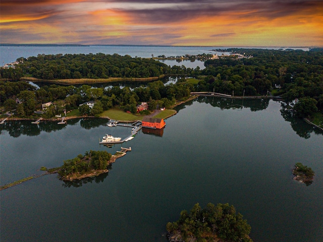 aerial view at dusk featuring a water view