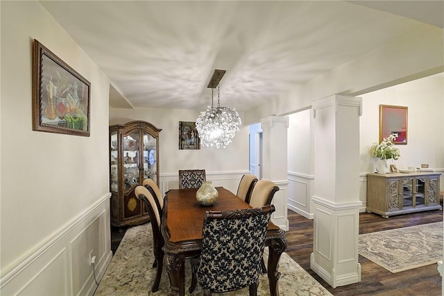 dining room featuring ornate columns and dark wood-type flooring