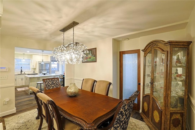 dining room with hardwood / wood-style floors, a chandelier, and sink