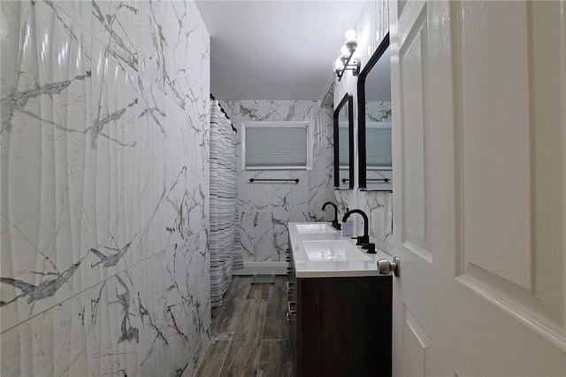 bathroom featuring curtained shower, vanity, wood-type flooring, and tile walls