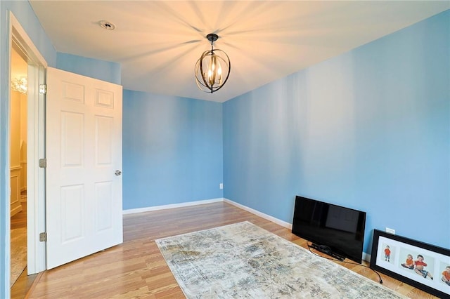 unfurnished room featuring hardwood / wood-style floors and a chandelier