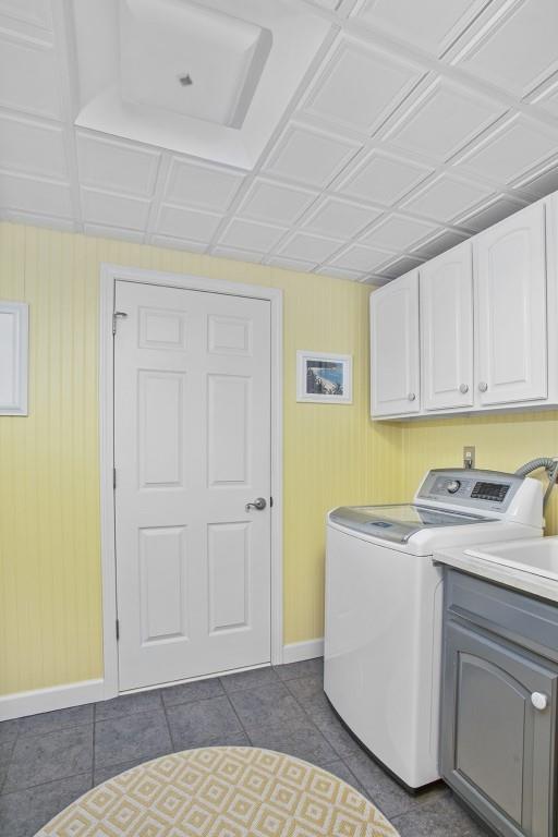 laundry area with tile patterned floors and cabinets