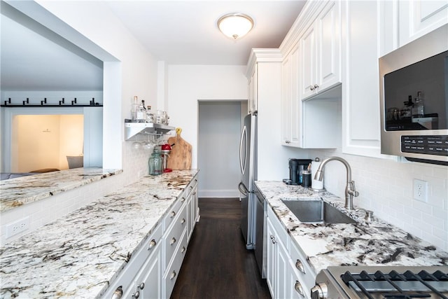 kitchen with decorative backsplash, appliances with stainless steel finishes, dark wood-type flooring, sink, and white cabinets