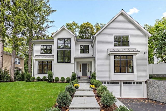 modern farmhouse featuring a garage and a front lawn